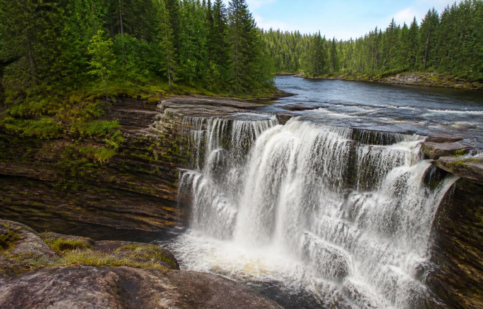 Exploits Falls, a wide waterfall in rural Newfoundland surrounded by forest and layered rock